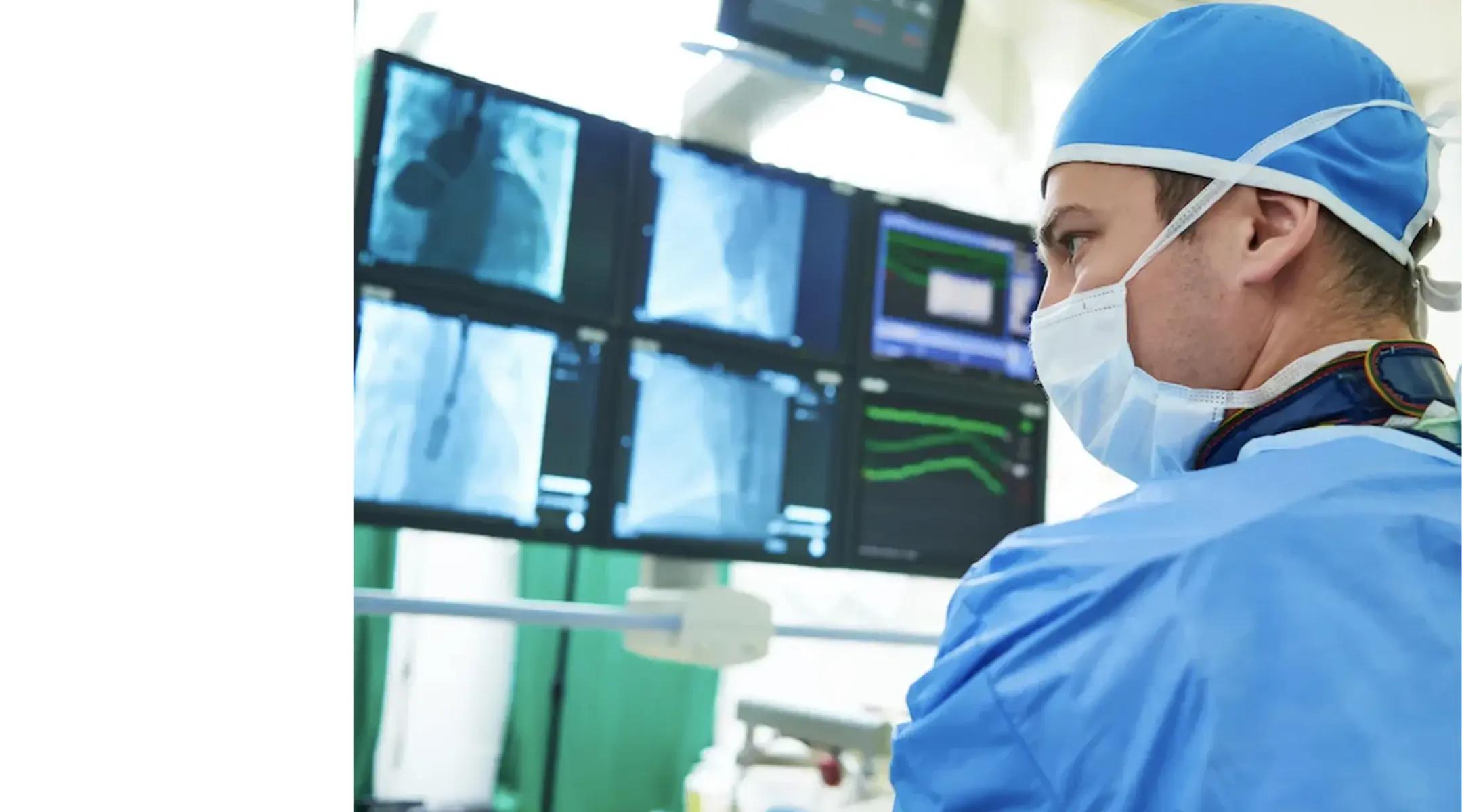 Physician looking at monitors in operating room